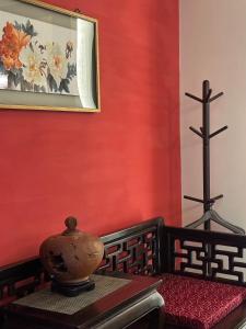 a room with a red wall with a vase on a table at After the Court Chiaohsi in Jiaoxi