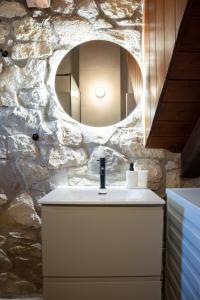 a bathroom with a white sink and a stone wall at Achyronas 1840 Stone House in Graviá +32 photos