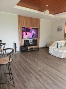 a living room with a flat screen tv and a couch at Casa La Herencia in Huaral