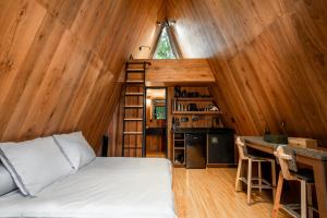 a bedroom with a bed and a desk in a room at WANDER CABINS Valle de Bravo in Valle de Bravo