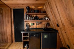 a kitchen with a black counter and a sink at WANDER CABINS Valle de Bravo in Valle de Bravo