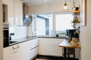 a kitchen with white cabinets and a large window at Garden Spa Suite - Private Sauna & Whirlpool in Betzdorf