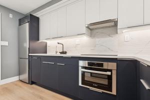 a kitchen with black and white cabinets and a sink at 24 Stay - Philadelphia Rittenhouse in Philadelphia