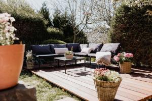 a blue couch sitting on a wooden deck with plants at Garden Spa Suite - Private Sauna & Whirlpool in Betzdorf