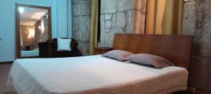 a bedroom with a bed with two pillows and a mirror at Quinta Da Lagoa GuestHouse in Vila Real