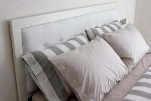 a white headboard with three pillows on a bed at Home BB Milano in Milan +56 photos