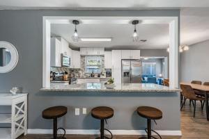 a kitchen with a counter and stools in a room at Ocean Blue Heated Pool Home in Largo