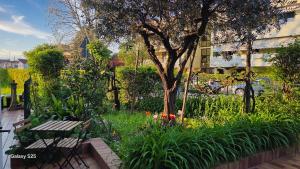 a garden with a bench and a tree and flowers at Casa Kendra in Montegrotto Terme