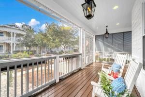a porch with two chairs and a table on a deck at SeaPines on 30A in Santa Rosa Beach