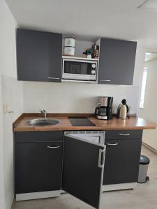 a kitchen with a sink and a microwave at Ferienwohnung Nicole in Schneeberg