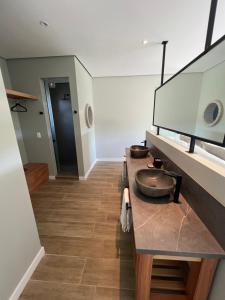 a bathroom with a counter with a sink and a mirror at Buenos Vientos Casa de Campo in Maldonado