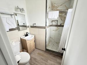 a bathroom with a shower and a toilet and a sink at Bayshore Inn Ventura in Ventura +32 photos