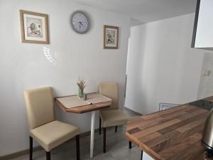 a dining room table with chairs and a clock on the wall at Ferienwohnung Nicole in Schneeberg