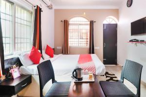 a hotel room with a bed and a table and chairs at Capital O The Tulip in Rānchī