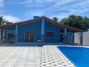 a blue house with a swimming pool in front of it at Casa em jacuma vip in Conde