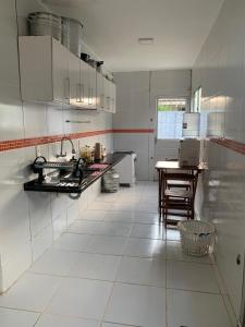 a large white kitchen with a table in it at Casa em jacuma vip in Conde
