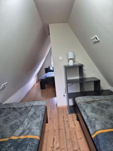 a attic room with two beds and a table at Ferienhaus am Helenesee 17 in Frankfurt Oder