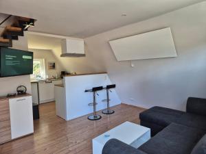 a living room with a couch and a kitchen at Ferienhaus am Helenesee 17 in Frankfurt Oder