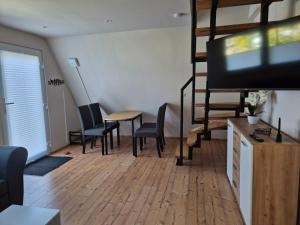 a living room with a tv and a table and chairs at Ferienhaus am Helenesee 17 in Frankfurt Oder
