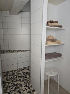 a bathroom with white walls and a stool and shelves at Ferienwohnung Nicole in Schneeberg