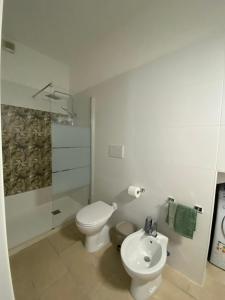 a white bathroom with a toilet and a sink at Nardò apartment in Nardò +14 photos