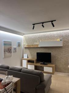 a living room with a couch and a flat screen tv at Nardò apartment in Nardò