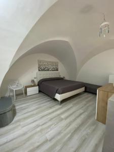 a bedroom with a bed and a wooden floor at Nardò apartment in Nardò