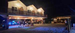 a group of people standing outside of a building at night at Cabañas Privadas San Carlos Escape & Relax in Ensenada