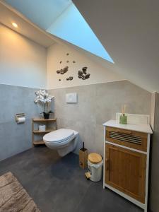 a bathroom with a toilet and a sink at Mira Suites 3 in Schwalbach