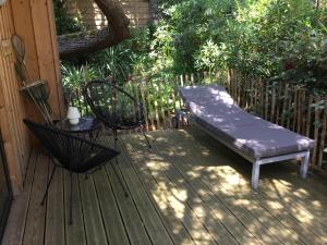 a bench and a table on a wooden deck at Cabane dans la verdure in Lège-Cap-Ferret +10 photos
