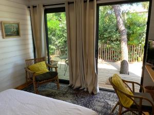 a bedroom with a bed and a sliding glass door at Cabane dans la verdure in Lège-Cap-Ferret