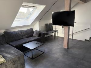 a living room with a couch and a flat screen tv at Mira Suites 3 in Schwalbach