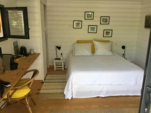 a bedroom with a white bed and a desk at Cabane dans la verdure in Lège-Cap-Ferret