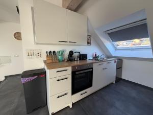 a small kitchen with white cabinets and a window at Mira Suites 3 in Schwalbach +19 photos