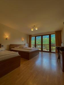a large bedroom with two beds and a balcony at Panorama Pietrei Craiului in Zărneşti