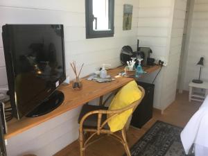 a room with a desk with a large television at Cabane dans la verdure in Lège-Cap-Ferret