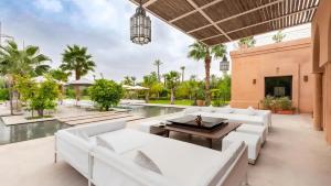 an outdoor living room with white furniture and a swimming pool at Dreamcation Villa in Marrakesh