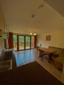 a living room with a table and a couch at Panorama Pietrei Craiului in Zărneşti