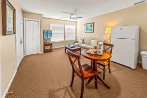 a living room with a couch and a table and a refrigerator at Cozy 1st floor condo with golf course view in New Bern +13 photos