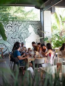 Eine Gruppe von Menschen sitzt an einem Tisch in einem Restaurant in der Unterkunft Ancora Punta Mita in Punta Mita