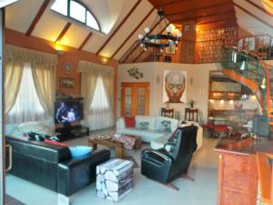 a living room with black leather furniture and a staircase at Keith Lakewood Villa in Balatonfüred