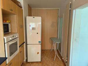 a kitchen with a white refrigerator and a microwave at Chambre spacieuse - appart sympa chez l'habitant in Saint-Herblain