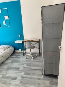 a bedroom with a desk and a table with a chair at Chambre spacieuse - appart sympa chez l'habitant in Saint-Herblain