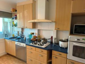 a kitchen with wooden cabinets and a blue counter top at Chambre spacieuse - appart sympa chez l'habitant in Saint-Herblain