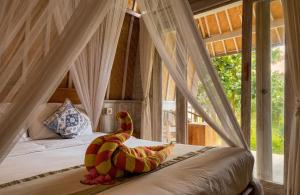 a bedroom with a bed with a dinosaur on it at The Dafish Ceningan in Nusa Lembongan