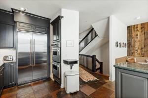 a kitchen with a stainless steel refrigerator and a staircase at Pine Meadows 135 ~ Pine Meadows 135 in Telluride