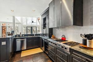 a kitchen with black cabinets and stainless steel appliances at Pine Meadows 135 ~ Pine Meadows 135 in Telluride