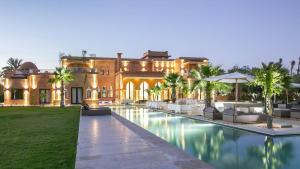 a house with a swimming pool in front of a building at Dreamcation Villa in Marrakesh