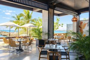 ein Restaurant mit Tischen und Stühlen und Meerblick in der Unterkunft Ancora Punta Mita in Punta Mita
