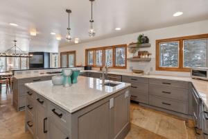 a large kitchen with gray cabinets and a large island at Benchmark Dr 101 in Telluride